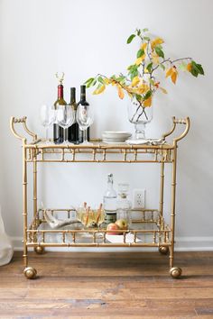 a gold bar cart filled with drinks and glasses