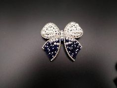 Silver Bow Brooch For Wedding, Elegant Crystal Pins For Party, Elegant Silver Beaded Brooches, White Decorative Bow Jewelry For Wedding, Elegant Party Brooches With Bling, White Jewelry With Decorative Bow For Wedding, White Wedding Jewelry With Decorative Bow, Elegant Blue Wedding Brooches, White Rhinestone Brooches For Formal Occasions