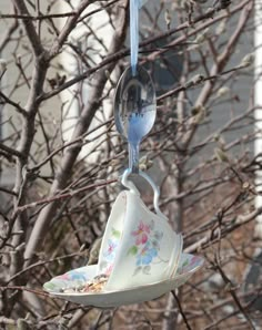 a bird feeder hanging from a tree filled with birds