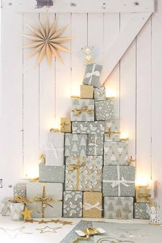 a small christmas tree made out of wrapped presents with gold and silver wrapping around it