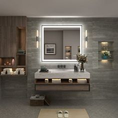 a bathroom with a large mirror above the sink and lights on the wall behind it