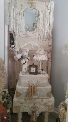 an old dresser is decorated with white flowers and laces on the top, along with other antique furniture