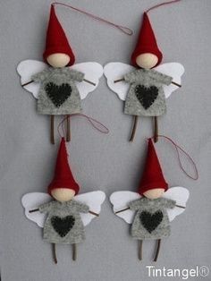 three little gnomes are hanging on the wall with hearts in their ears and wings