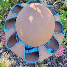 Looking for a dimensional hat?    Something a bit different that everyone else? This is a one of a kind hand stretched over a hat block wool carmel hat with blue hand stitching around the brim. Hat band is blue and white ribbon with a round floral copper pendant.  The copper pendant is embossed with texture. Hand painted flowers in matching blue and white on the underside of the brim with burned embellishments in the middle of each flower.   SIZE:  Adult Medium or 21-23 1/2inches. To see how to measure your fit please check out the video. NO EXCHANGES OR RETURNS IN THE USA. Adjustable Blue Cloche Hat With Flat Brim, Brimmed Felt Hats For Kentucky Derby, Bohemian Adjustable Felt Hat, Adjustable Handmade Brown Cloche Hat, Unique Brown Hat With Curved Brim, One Size Fits Most Felt Hat For Kentucky Derby, Kentucky Derby Brown Felt Hat For Beach, Brown Felt Hat For Kentucky Derby, Festival Wide Brim Felt Hat