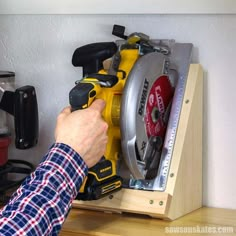 a man is using a circular saw to cut the holes in a cabinet with tools