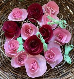 pink and red paper roses in a wicker basket with twine on the top