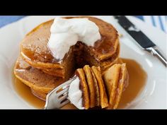 a plate topped with pancakes covered in syrup and whipped cream