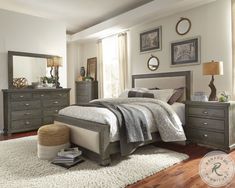 a bedroom scene with focus on the bed and dressers in the foreground, along with an area rug