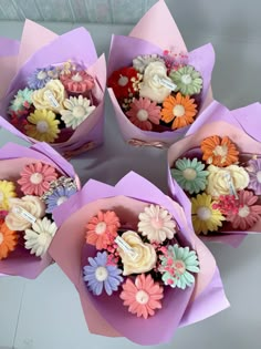 four paper flowers are arranged in the shape of bouquets with numbers and letters on them