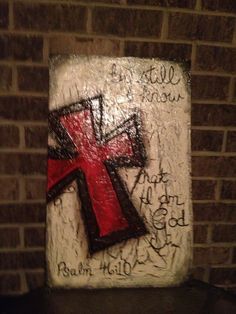 a cross painted on the side of a brick wall