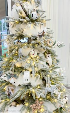 a white christmas tree decorated with ornaments and lights