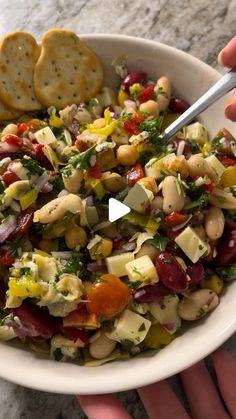 a white bowl filled with salad and crackers