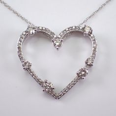 White Gold Diamond Heart Pendant with Chain. This heart is set with fifty-six genuine Round Brilliant Diamonds.  These diamonds are H color, I1 clarity and combine to a total weight of 1/2 carats. This pendant and chain are both 10K White Gold and weigh a total of 2.2 grams. The heart measures 20 X 22 mm. This necklace is accompanied by an appraisal, valued at $1,495.00.  The necklace will be shipped promptly in a gift box. ADDITIONAL REQUESTS If you would like to see more pictures of this item, Heart Cut Diamond White Necklace With 17 Jewels, Classic Diamond Cut Necklace For Valentine's Day, Diamond White Heart Pendant Necklace With 17 Jewels, Heart-shaped Cubic Zirconia Diamond Necklace, Fine Jewelry Gemstone Heart Necklace For Anniversary, Fine Jewelry Heart Necklace With Gemstone For Anniversary, Elegant Gemstone Heart Necklace For Anniversary, Formal Heart-shaped Jewelry With Prong Setting, Dazzling Heart-shaped Jewelry For Weddings