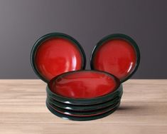 red mickey mouse ears are stacked on top of each other in front of a gray background