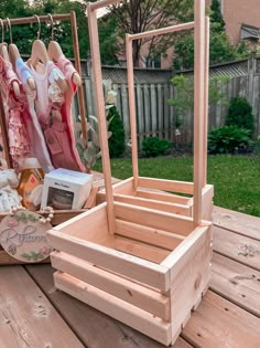 a wooden box with clothes hanging from it's sides on top of a table