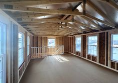 an empty room with wood framing and windows on the second floor that is being built