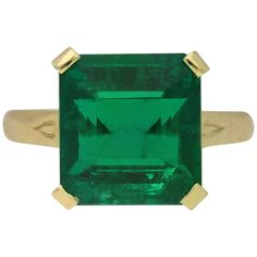 Vintage emerald solitaire ring. Centrally set with an octagonal emerald-cut natural Zambian emerald with moderate clarity enhancement in an open back claw setting with an approximate weight of 5.30 carats, to a striking solitaire design featuring corner claws, a linear pierced gallery and square open backholing, flanked by openwork trumpeting shoulders with engraved detailing flowing to a solid tapering D-shape shank. Marked 18 carat yellow gold, circa 1980, accompanied by Gemmological Certifica Engagement Ring 4 Carat, Decadent Wedding, Emerald Statement Ring, Emerald Gold Ring, Antique Emerald Ring, Emerald Solitaire Ring, Gold Ring Unique, Emerald Wedding Rings, Rings Style