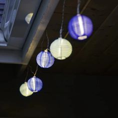 three blue and white paper lanterns hanging from the ceiling