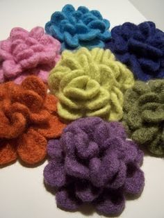 six different colors of hair scrunffles on a white table top with one flower in the middle