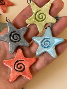 four star shaped ornaments are being held in someone's hand