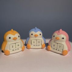 three ceramic penguin figurines sitting next to each other