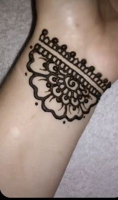 a woman's foot with a henna tattoo on it