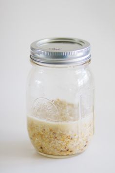 a glass jar filled with oatmeal sitting on top of a white table