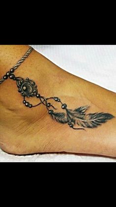 a woman's foot with a feather and beads tattoo on the bottom of it