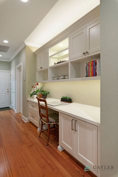 an empty room with white cabinets and wood flooring is seen in this image from the hallway