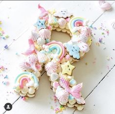 a decorated letter made out of cookies sitting on top of a white table next to confetti and sprinkles