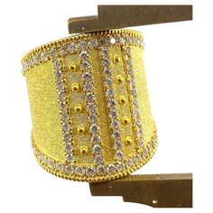 You are admiring S.Georgios designer 18 Karat Solid Yellow Gold Wide Ring all handmade in Byzantine style and a stunning unique velvet background. This gorgeous ring features 1.08 Carats of Brilliant-cut White Diamonds around the edges and in intricate lines. This ring is a beautiful combination of the byzantine technique and a very modern design. This look can be also ordered in all White, or Rose Gold, please contact us. The ring is outstanding in the quality of workmanship and stone collectio Luxury Gold Diamond Ring With Hand Set, Luxury Hand Set Gold Diamond Ring, Luxury Hand-set Gold Diamond Ring, Elegant Gold Diamond Ring For Ceremonial Occasions, Gold Wide Band Ring With Diamond Accents, Luxury Gold Jewelry With Decorative Band, Luxury Yellow Gold Rings With Bling, Luxury Hallmarked Wide Band Jewelry, Yellow Gold Bling Rings For Wedding