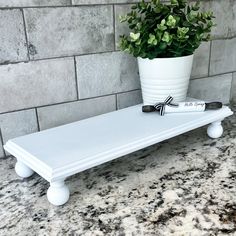 a potted plant sitting on top of a white shelf