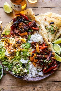 a plate full of mexican food with rice, meat and veggies on it