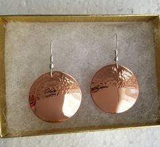 Hammered solid copper earrings on sterling silver ear wires. I hammered only the top half of the copper disc which is domed slightly. Available in two sizes, medium,1 inch in diameter, and large,1&1/2 inches in diameter. I also have these in a completely hammered version listed. Shipped in a gift box to protect during shipment. Hammered Metal Earrings, Copper Jewellery Handmade, Hammered Copper Drop Earrings, Bronze Round Earrings, Bronze Copper Round Earrings, Hammered Rose Gold Copper Earrings, Nickel-free Copper Circle Earrings, Copper Earrings Handmade Ideas, Hammered Copper Earrings For Gift