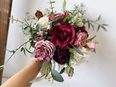 a person holding a bouquet of flowers in their hand