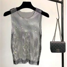 Elevate Your Party And Club Style With This Exquisite Crystal Beading Shiny Tank. This Sexy And Glamorous Sleeveless Vest Is Adorned With Intricate Crystal Beading, Adding A Touch Of Sparkle To Your Outfit. Its Hollow-Out Design And Diamond Stamping Details Give It A Trendy And Edgy Edge. Whether You're Hitting The Club Or Attending A Special Event, This Winky Sleeveless Vest Is The Perfect Choice To Make A Bold And Fashionable Statement. Stretch Rhinestone Tank Top For Party, Party Stretch Tank Top With Rhinestones, Stretch Tank Top With Rhinestones For Party, Embellished Tank Top For Night Out In Summer, Embellished Tank Top For Summer Night Out, Silver Sleeveless Tank Top For Club, Glamorous Sleeveless Tank Top For Club, Summer Stretch Tank Top With Rhinestones, Silver Stretch Tank Top For Summer