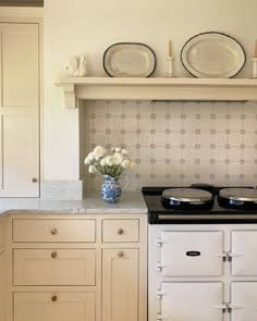 a white stove top oven sitting inside of a kitchen next to a wall mounted oven