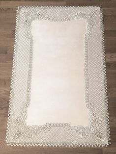 a white rug with an ornate border on the floor