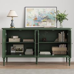 a green bookcase with books and magazines on it in front of a wall mounted painting