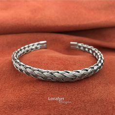 You will love this amazing bracelet crafted from 5 small stainless steel wires braided in a spiral pattern. The smooth 1/4 inch wide braid is finished at each end with with rounded stainless steel caps to ensure nothing will catch on your clothes or scratch your skin. The round braid design makes the bracelet flexible which allows you to easily expand the opening while maintaining its shape. In total the length of the bracelet is 7 inches and I recommend for wrists sizes 6.5 to 9 inches. Since i Adjustable Silver Stainless Steel Braided Bracelet, Adjustable Stainless Steel Braided Bangle Bracelet, Adjustable Stainless Steel Braided Bracelet, Braided Metal Bracelets As Gift, Adjustable Braided Cuff Bracelet, Adjustable Braided Metal Bracelets, Adjustable Interwoven Bracelets As Gift, Silver Braided Hand-wrapped Bangle Bracelet, Silver Hand-wrapped Braided Bangle Bracelet