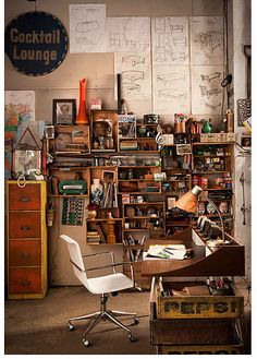 a room filled with lots of clutter next to a white chair and desk in front of a wall