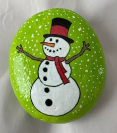 a painted rock with a snowman on it