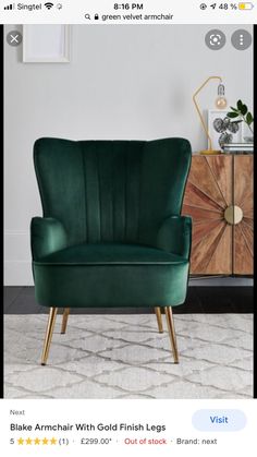 a green chair sitting on top of a rug next to a wooden cabinet and sideboard