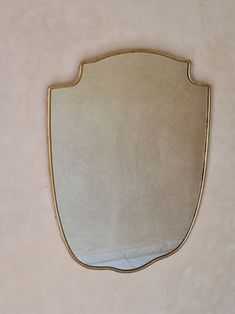 a mirror that is on the wall with a white and gold border around it's edge