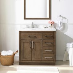 a bathroom with a sink, mirror and toilet paper roll on the floor next to it