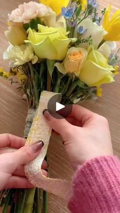 someone is making a flower bouquet out of wrapping paper