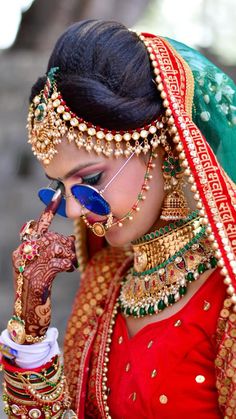 a woman in a pink and green bridal outfit is holding her hands out to the side