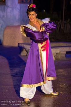 a man dressed in purple and gold poses for the camera