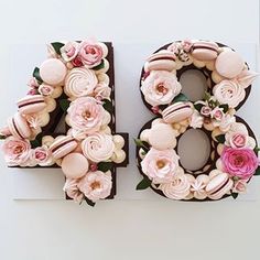 the number forty is decorated with pink flowers and chocolate frosted doughnuts on it