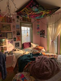 a bed room with a neatly made bed and lots of pictures on the wall above it